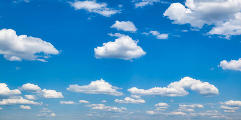 Panoramic view of cloudscape, amazing sky background. Panorama of blue sky with white fluffy clouds, atmospheric sunlight backdrop, cozy wallpaper. Design style backgrounds concept. Copy ad text space