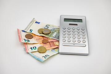 Euro banknotes and cent coins as loose change next to a calculator