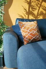 modern blue sofa with orange color pillows in living room at home
