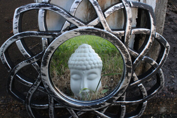 a buddha statue reflecting in a mirror 