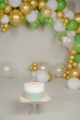 Cake with white cream, decorated with gold confectionery sprinkles on a white background. Two-tiered white wedding cake.