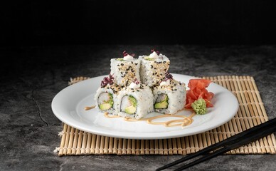 White plate with crab meat sushi rolls and marinated ginger
