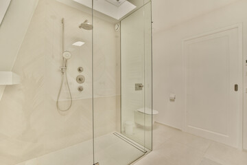 a bathroom with a glass shower door and white tiles on the wall behind it is a walk - in shower