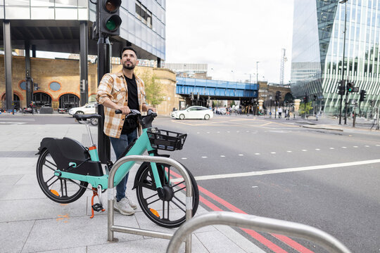 young hispanic tourist renting an electric bike in london to visit the city