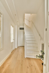 a room with wood flooring and white staircase leading up to the second floor in a home that is well maintained