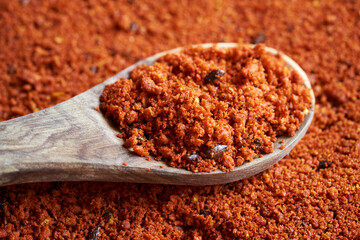 Orange sea buckthorn powder with seeds on a wooden spoon