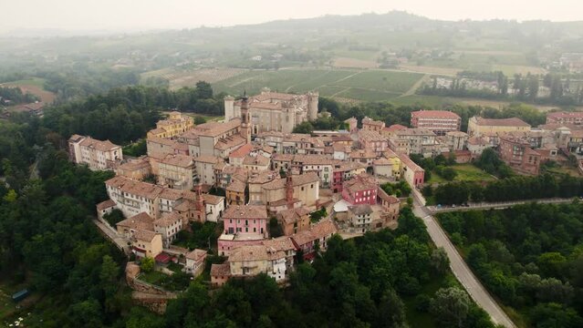 Drone view of Costigliole d'Asti village with vegetation in Province of Asti, Italy with misty sky