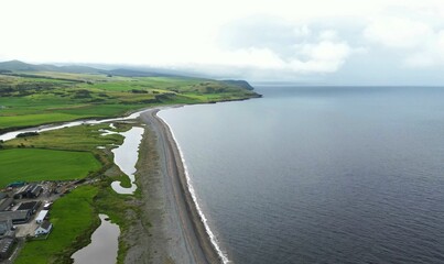 Aerial view of a tranquil sandy beach, with crystal clear water during cloudy weather in Scotland