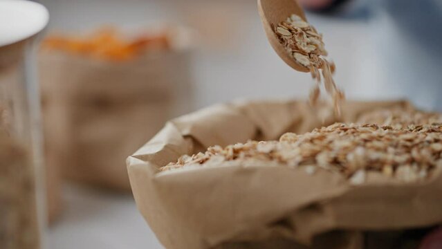 Fruits, woman business lady inspired by oat grains in hand hold oatmeal in private home. Tracking shot active woman keeping proper diet modern diet planning, kitchen