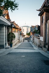 Fototapeta premium Picturesque view of a narrow road in South Korea, Seoul, at sunset, showcasing the cityscape below