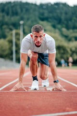 Obraz premium Fit, active man stands on a marked start line, ready to begin a workout
