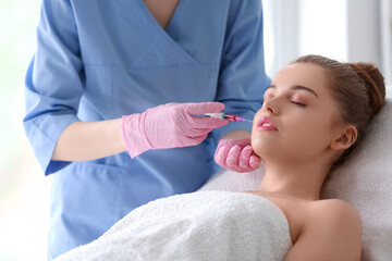 Naklejka premium Young woman receiving injection in beauty salon. Skin care concept