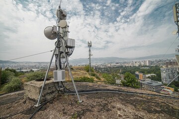 Cellular tower with cityscape below