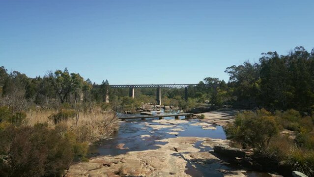 Aerial footage of the Quart Pot Creek Rail Bridge with forest trees in Stanthorpe, Australia