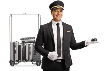 Bellboy holding a reception bell in front of a cart with suitcases