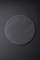 Empty black plate over dark stone background with copy space