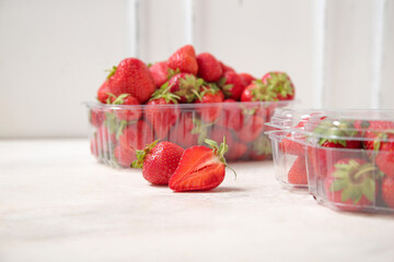 Plastic containers with fresh strawberry on white background, closeup