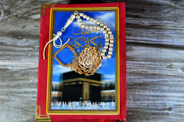 Makkah al-Mukarramah or Mecca the honored Quran, with blurry glowing picture of Kaaba, with silver...