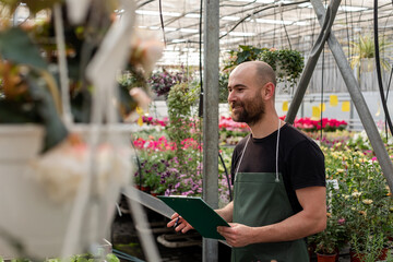 Florist works with plants inside greenhouse