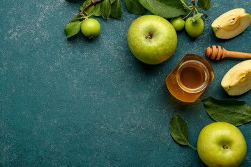 Jar of honey and apples for Rosh Hashanah celebration (Jewish New Year) on blue background