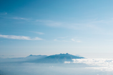 Scenic volcanos in blue sky over cloud