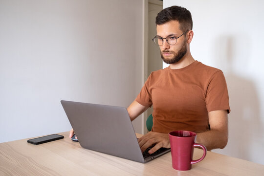 Anonymous male model working remote from home on his laptop