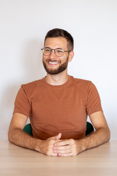 Portrait of a young male with glasses sitting and smilling 