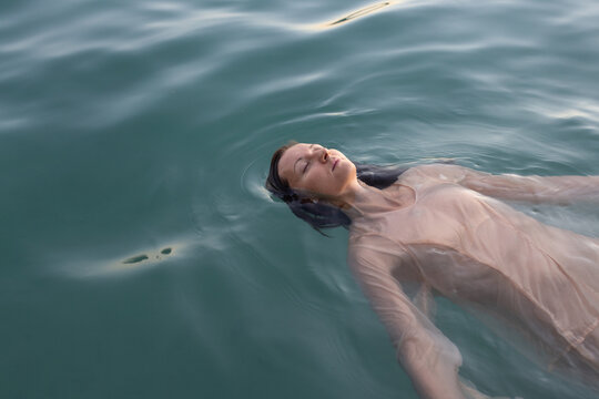 apathy, mental health, portrait of sad woman floating in water