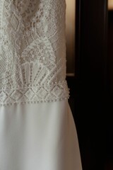 a close up view of a wedding dress hanging on a door