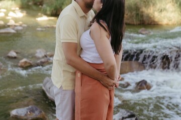 the man and woman are posing by a waterfall together in this photo