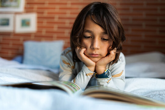 relaxed kid reading on bed