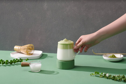 Composition with tasty dalgona matcha latte on green background. 