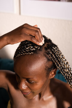Black woman fixing Afro braids after shower