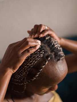 Black woman taking care of braided hair