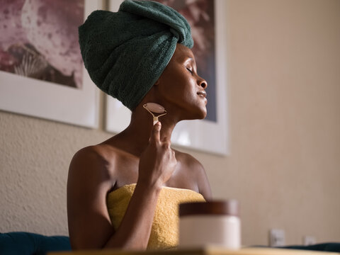 Black woman massaging neck after shower