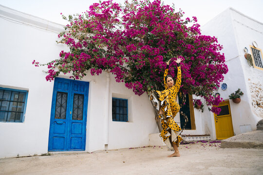 Gorgeous Gitana woman dancing flamenco near aged houses