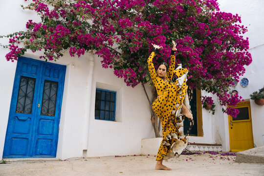Alluring barefooted woman dancing flamenco on street