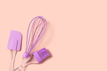 Pastry brush, whisk and spatula on pink background