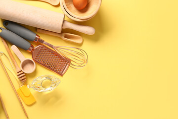 Wooden baking utensils on yellow background