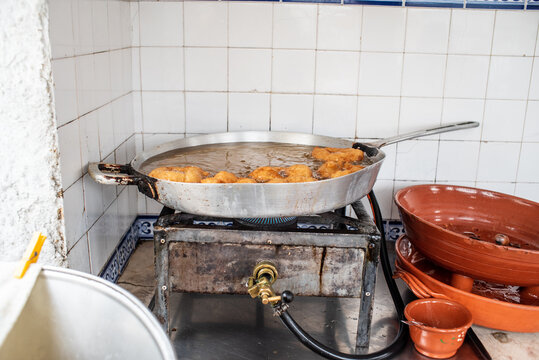 Making fried donuts in oil pan