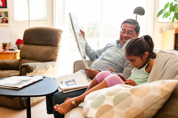 Granddad and grandchild reading on sofa