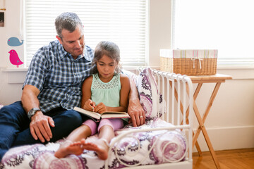Girl reading at home with her dad