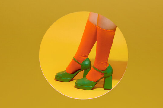 A Person In Color Socks And Green Shoes On A Yellow Background