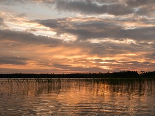 Fototapeta premium Closeup of a beautiful and vibrant sunset above a tranquil body of water
