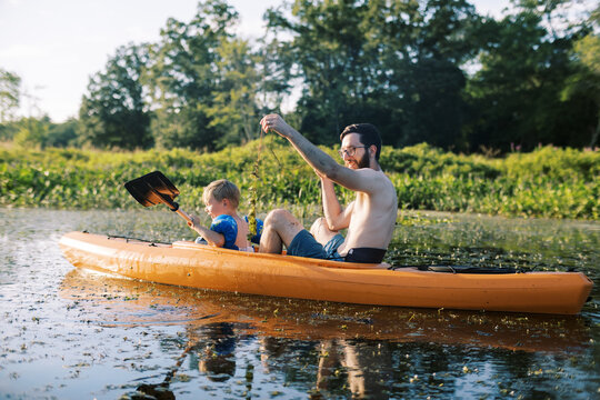 father and son kayaking together in a kayak on a river
