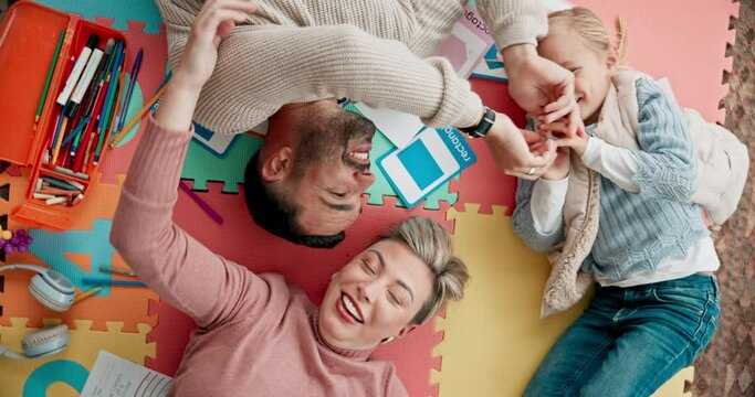 Top view, play and parents with child on floor for bonding, healthy relationship and relaxing together. Happy family, home and mom, dad and girl with creative toys for learning, development and fun