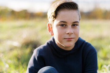 Smiling happy teen sitting in grass