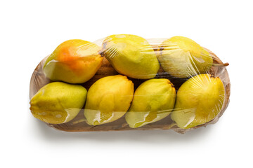 Wooden board of fresh pears covered with plastic food wrap on white background