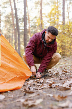 Camper fastening tent ground outside