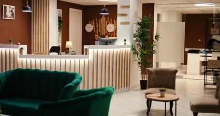 Wide angle shot of travel accommodation hotel lounge with check in reception desk. Stylish empty modern resort foyer interior with cozy furniture and warm fireplace ready to welcome tourists